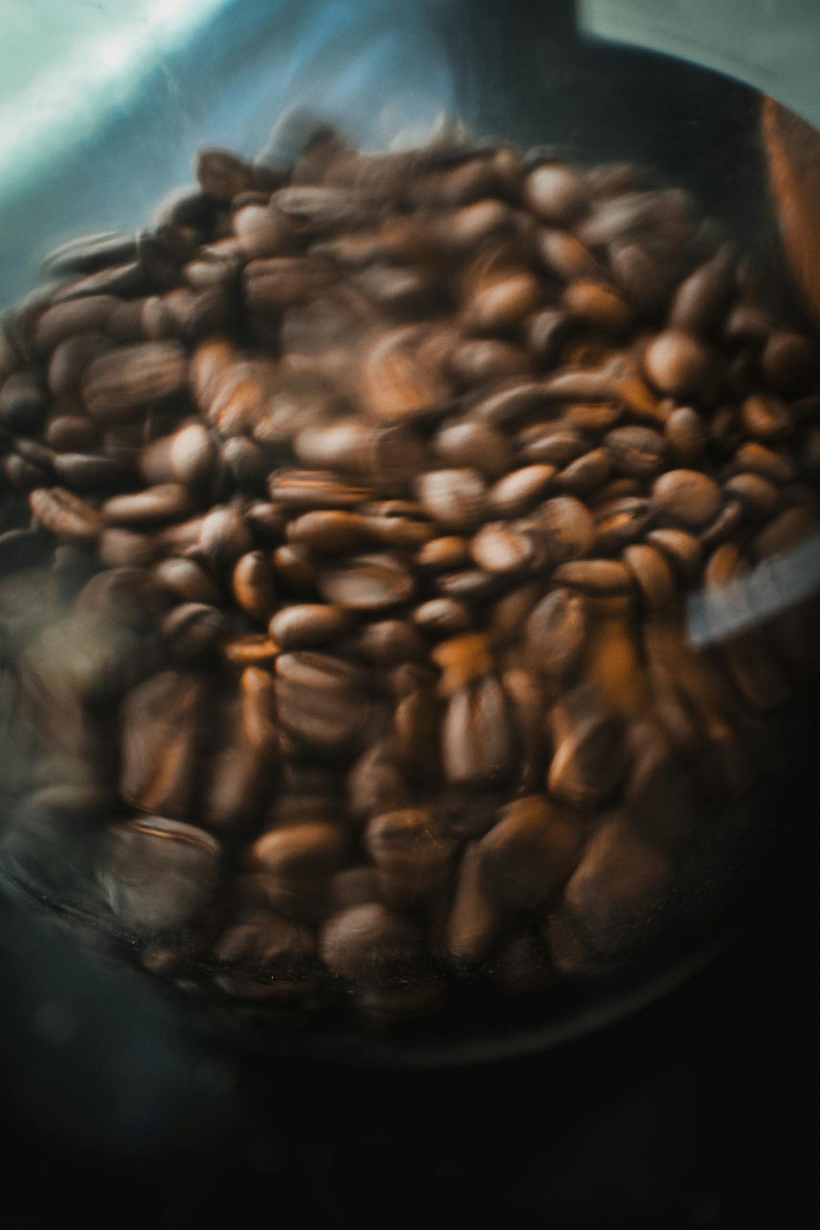 A blurred close-up of aromatic roasted coffee beans in a glass container.