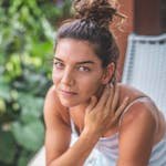 Charming portrait of a young woman sitting outdoors with a natural hairstyle.