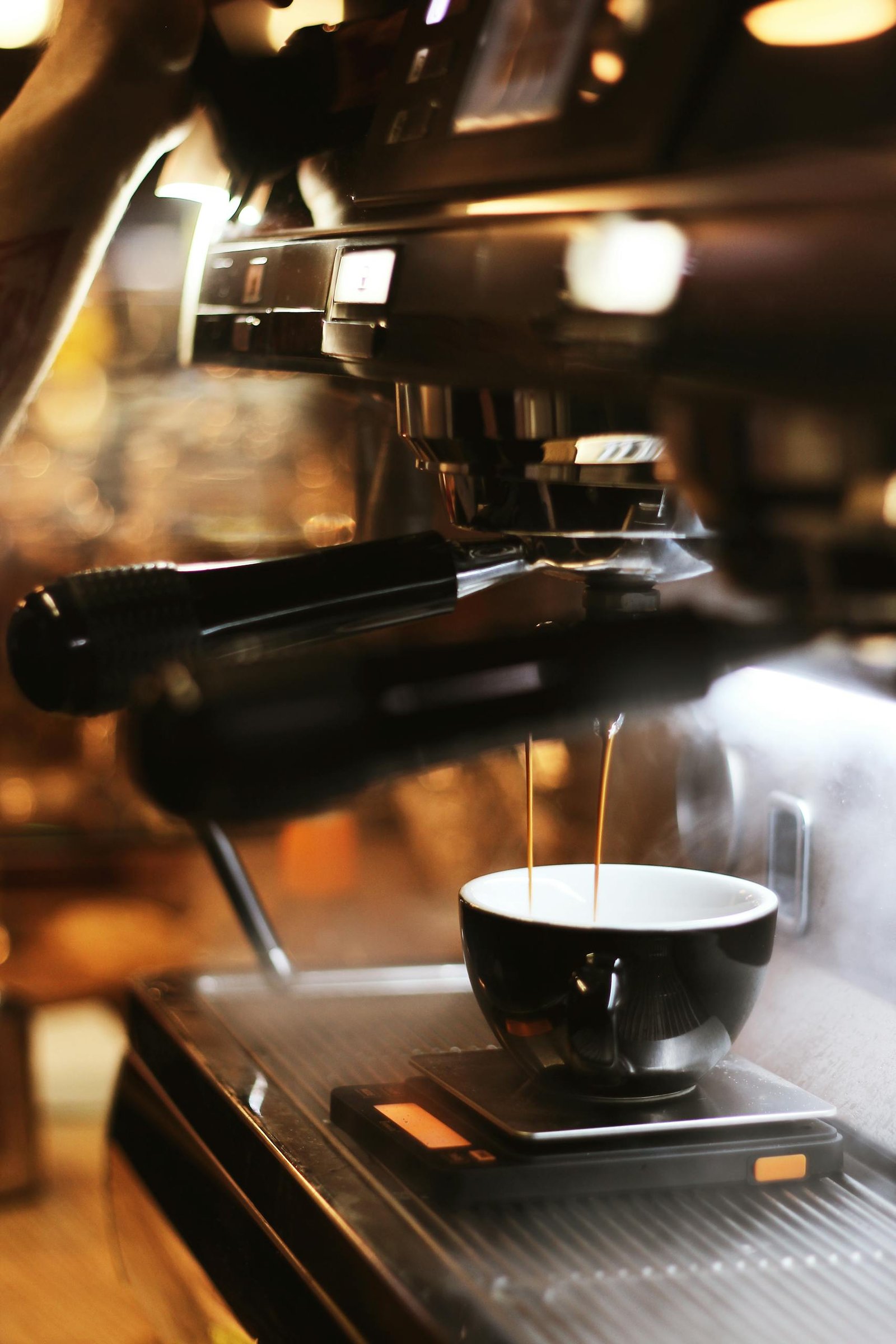 Close-up of espresso brewing process with modern coffee machine indoors.